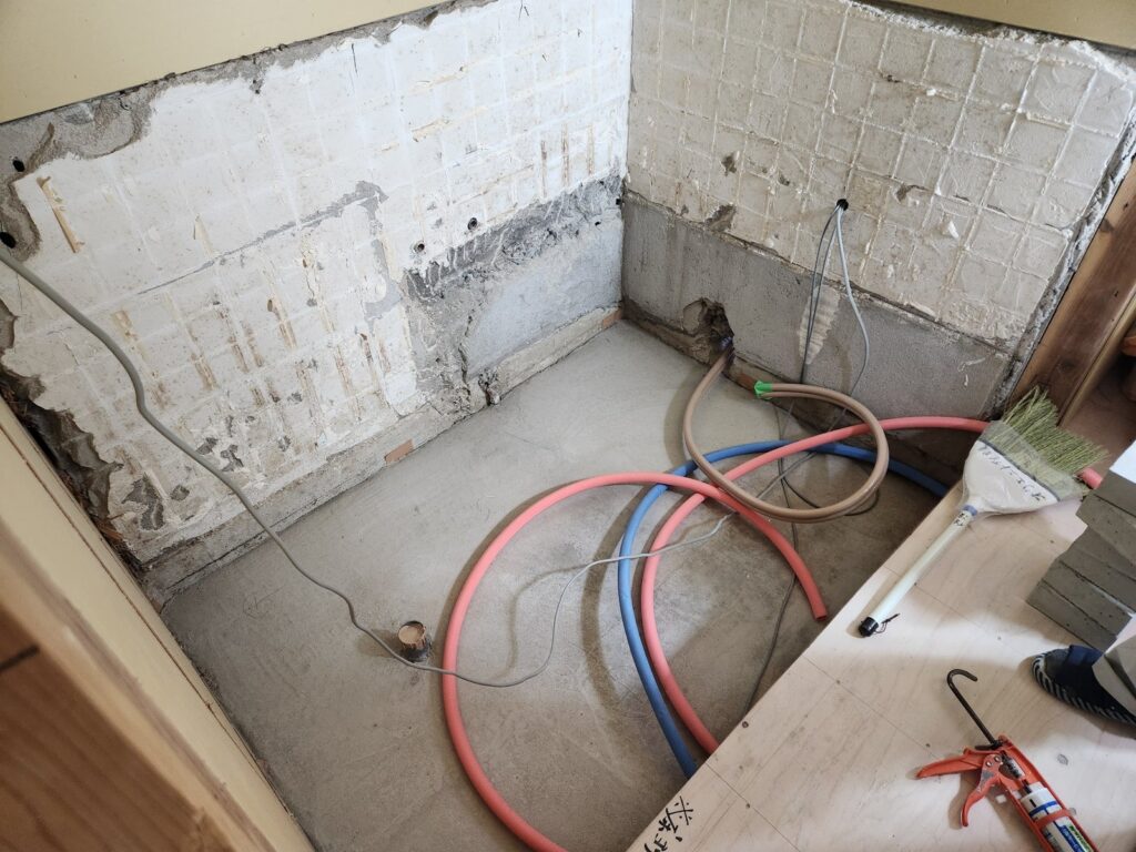 施工中：浴室の解体後、配管・土間を整えた状態。
